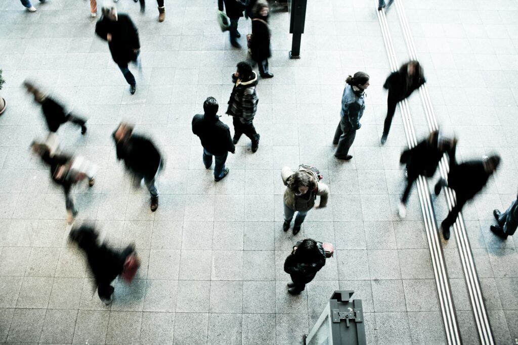timon-studler-ABGaVhJxwDQ-unsplash - Softwire A birdseye view of people walking in public. There is motion blur on the people.