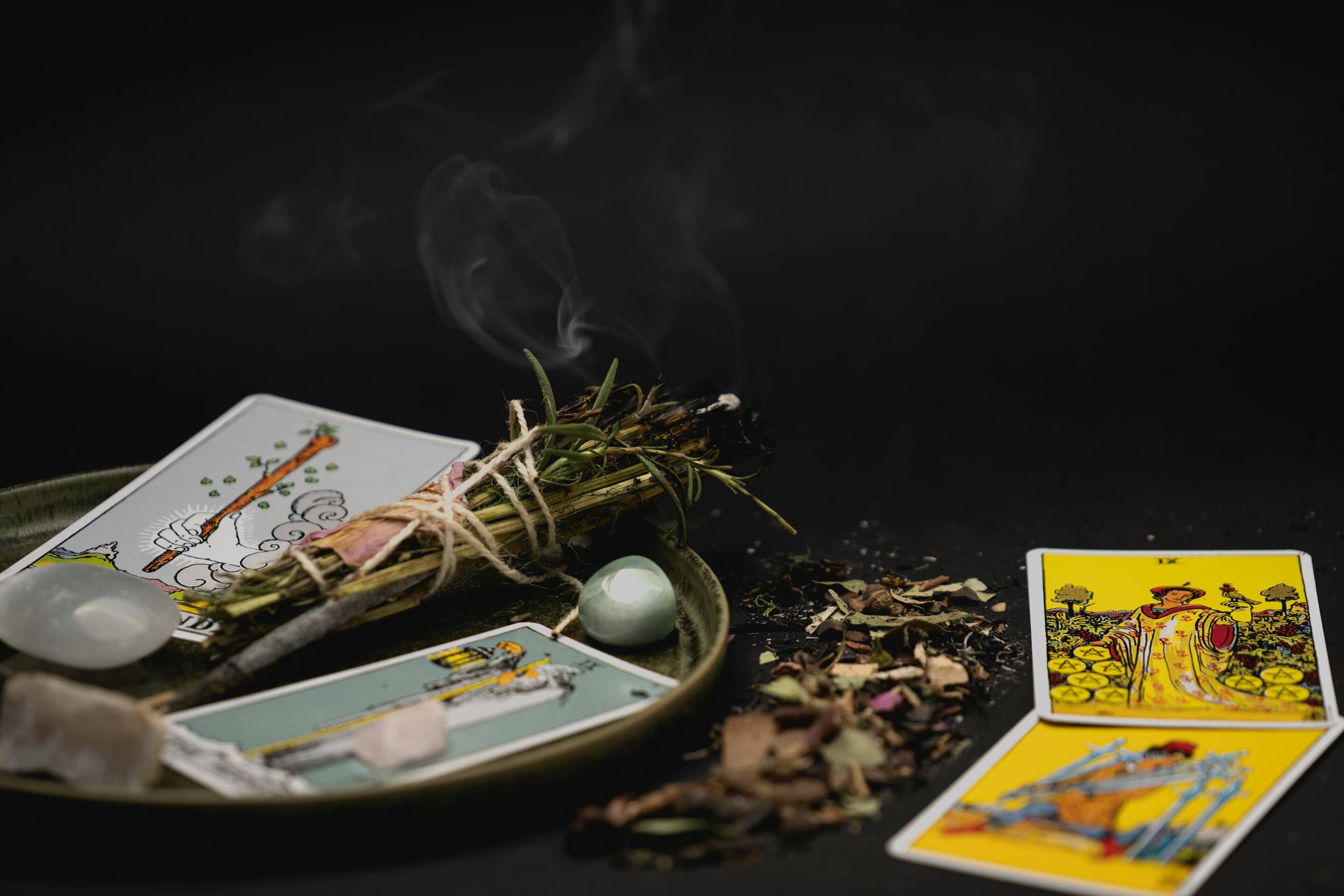 tarot-card-reader - Softwire A close up of a tarot readers apparatus including cards, smoking incense, and crystals