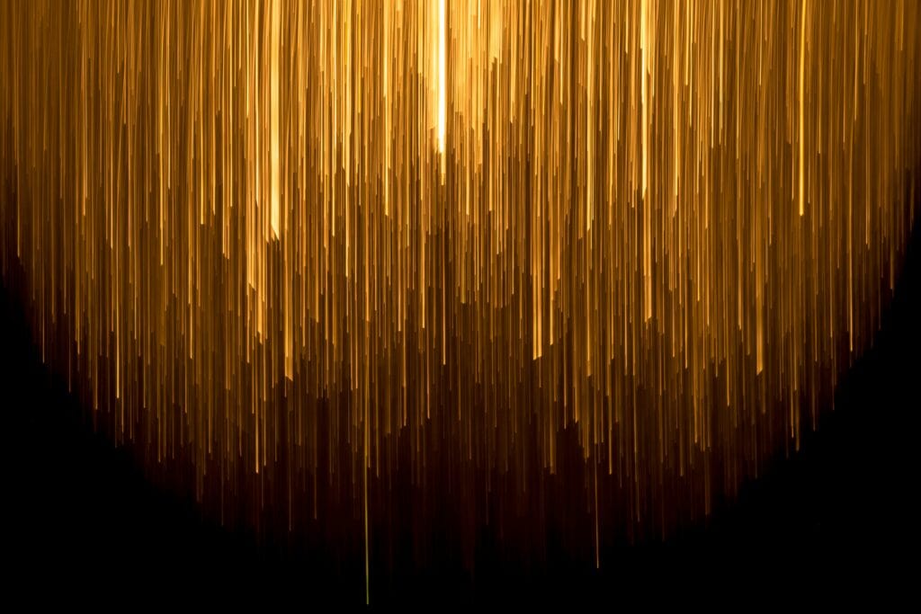 An abstract image representing a big computer, showing streams of gold lines descending from above.